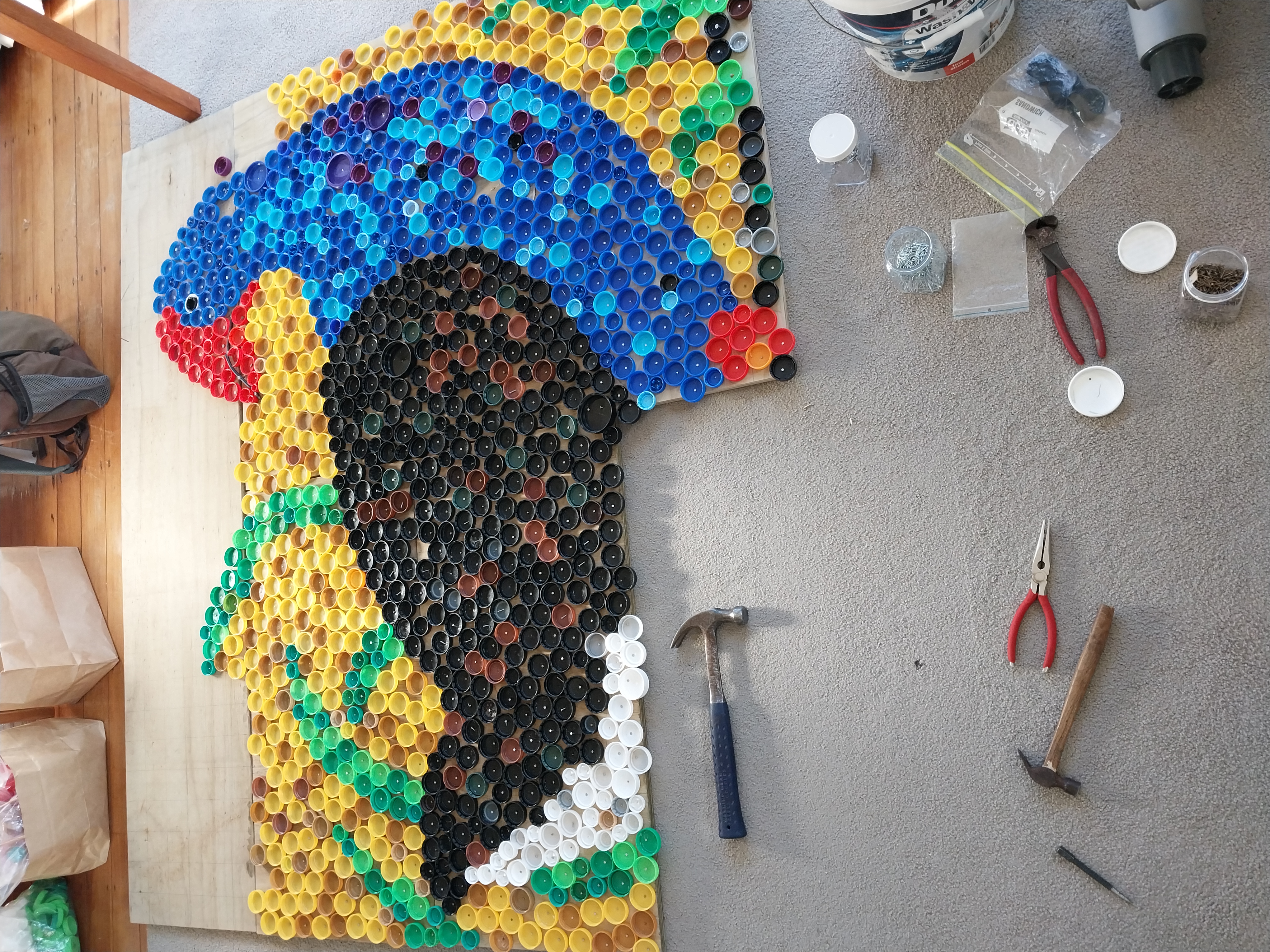 Plastic lid Pūkeko mural created by everyday environmentalist, Rowan